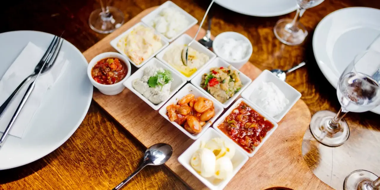 Meze-Platte mit verschiedenen Dips und Beilagen, wie Hummus und Salsa, serviert im Hasir Kreuzberg.