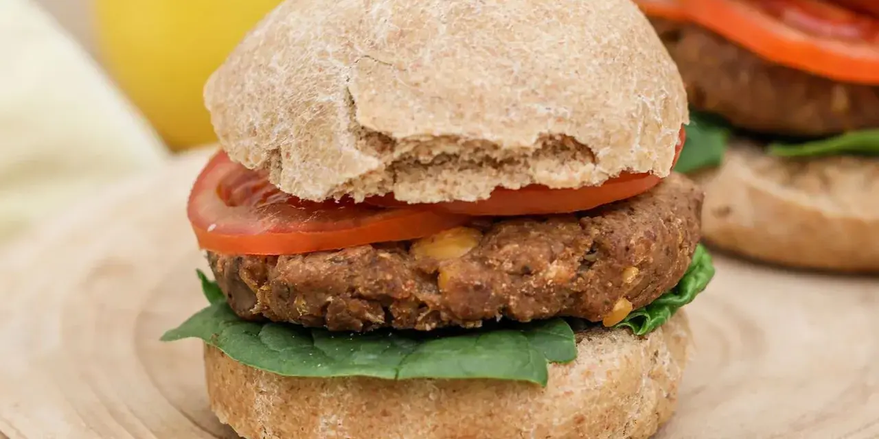Hamburguesa de legumbres con pan integral, tomate y espinacas.