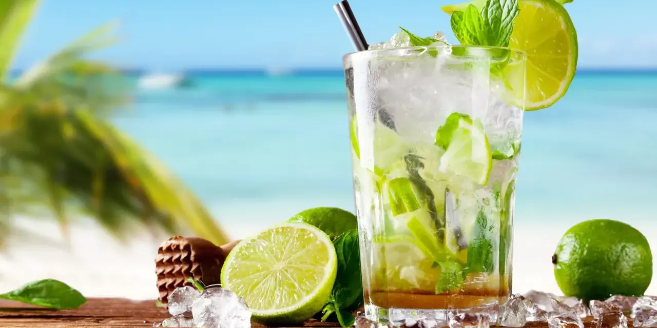 Orzeźwiający mohito drink co zamiast rumu? Idealny na plażę, z limonką i miętą, na drewnianym blacie, z widokiem na morze.