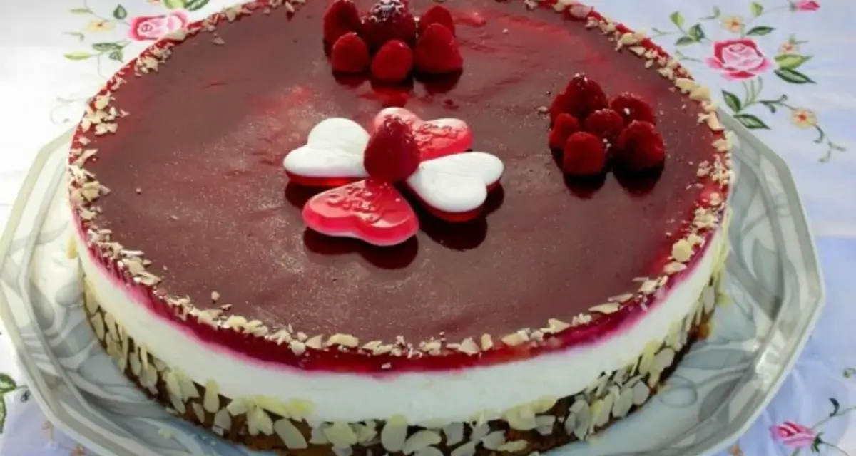 Himbeer Mohn Torte mit frischen Beeren und Herz-Gelees. Ein süßer Genuss für besondere Anlässe.