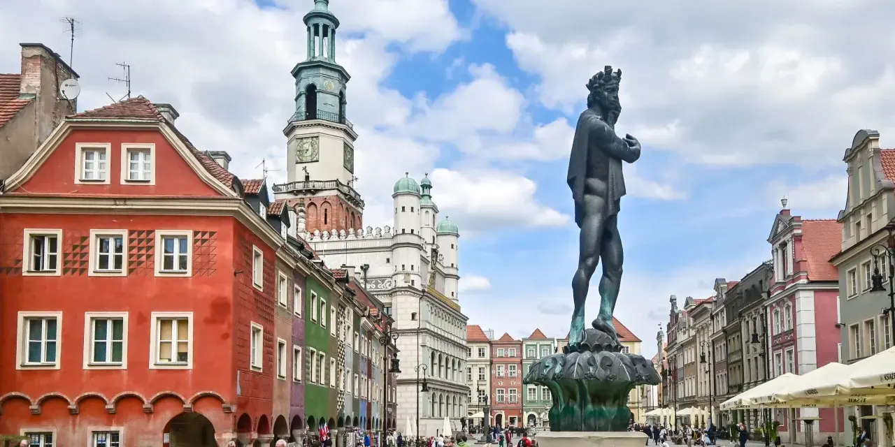 Rynek w Poznaniu z fontanną i kolorowymi kamienicami.