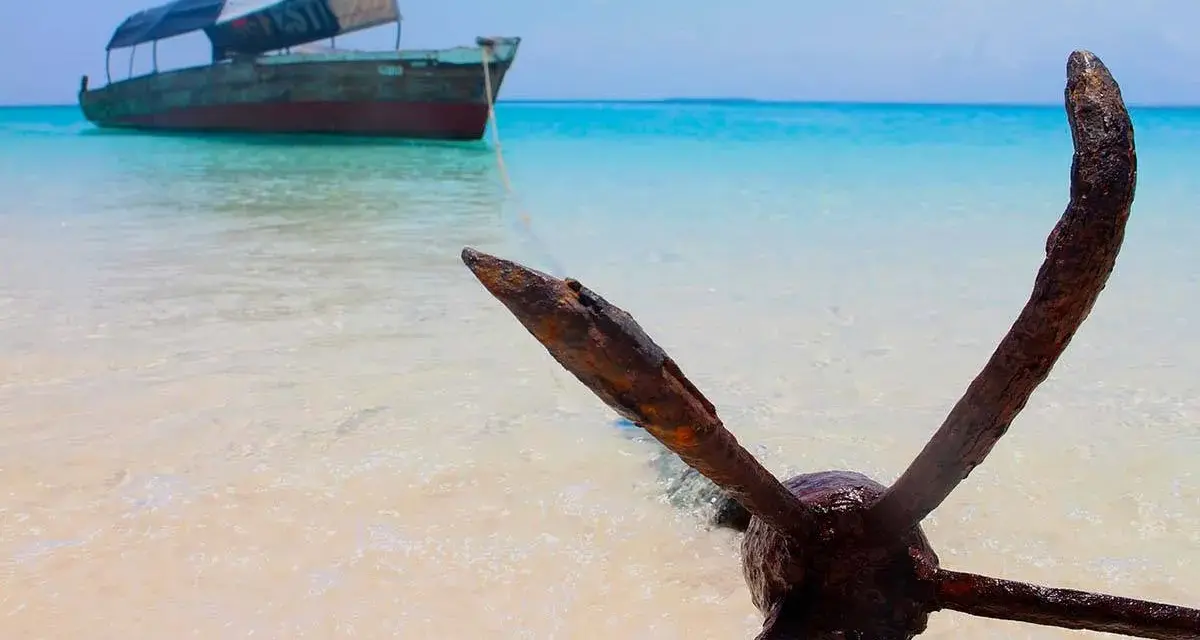 Kotwica na plaży, łódź na turkusowym morzu. Idealne miejsce na Zanzibar wycieczki fakultatywne.