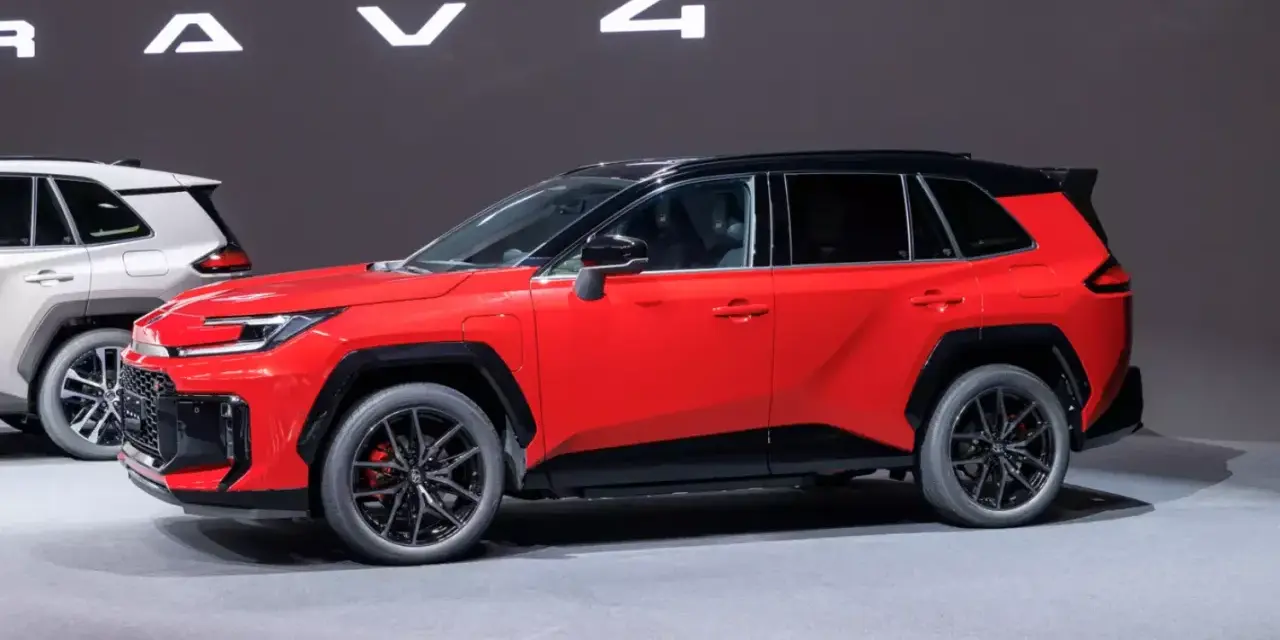 Czerwony, tani SUV z czarnym dachem i felgami, prezentowany na wystawie obok białego modelu.