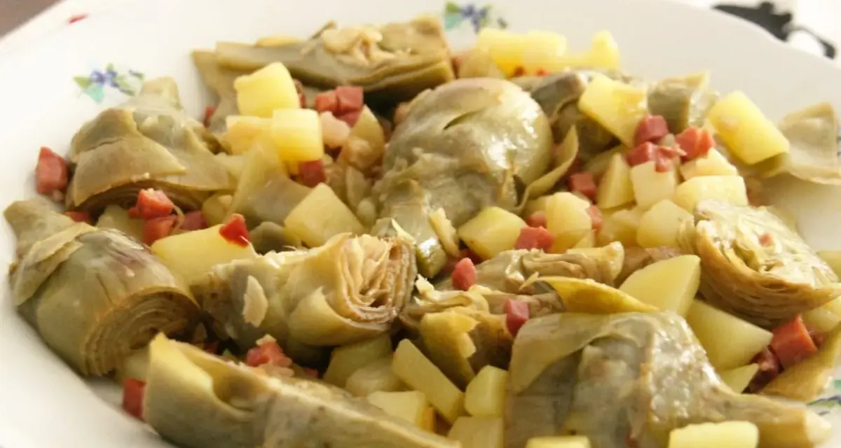 Plato de alcachofas tiernas y trocitos de jamón serrano, un clásico delicioso.