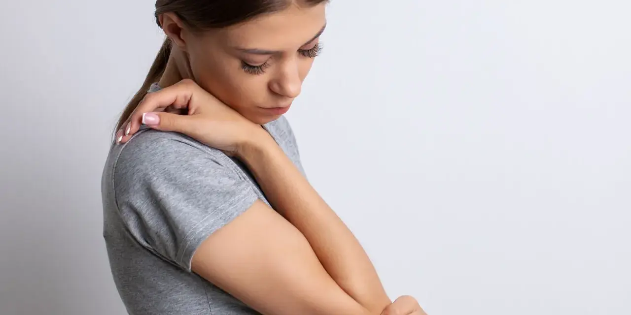 Mujer con dolor de codo, su piel con textura granulada se ve tensa.