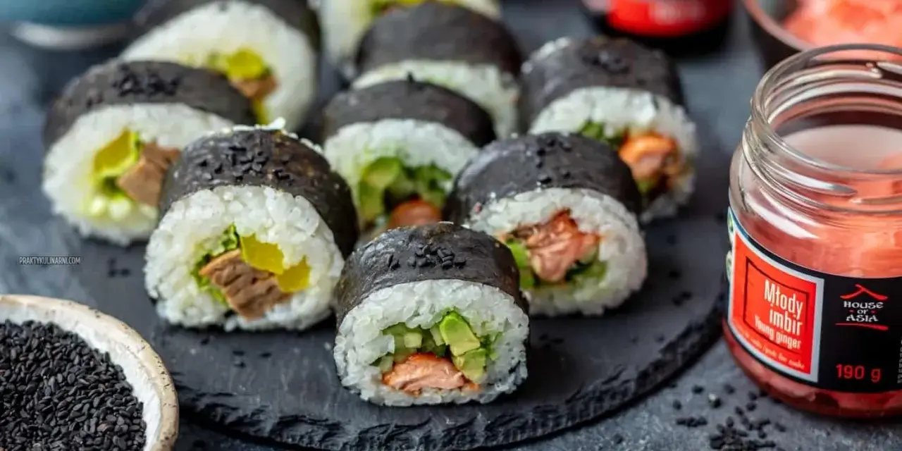 Gotowe sushi z łososiem i awokado, idealne do nauki jak zrobić sushi w domu. Obok słoiczek marynowanego imbiru.