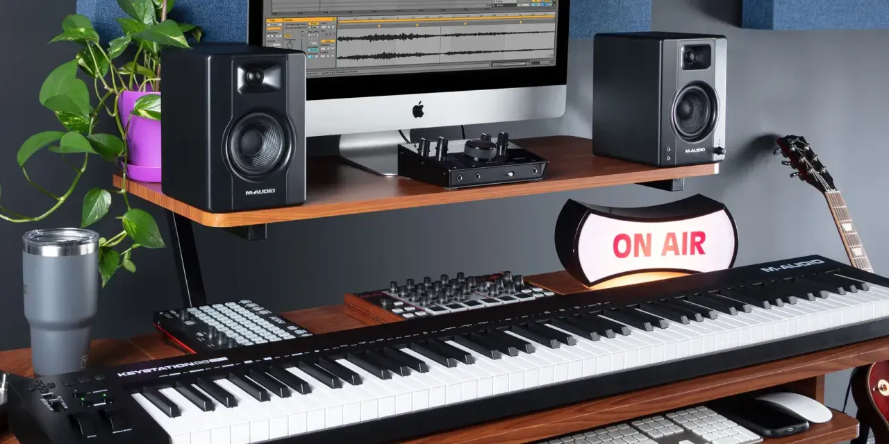 M-Audio Keystation 61, monitory studyjne, komputer z programem do produkcji muzyki, gitara i lampa "ON AIR" tworzą profesjonalne studio.
