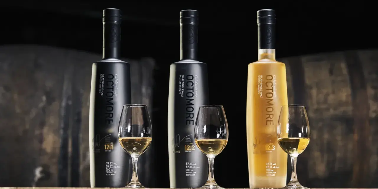 Trzy butelki Octomore, znanej z tego, że jest najbardziej dymna whisky, stoją obok kieliszków z bursztynowym płynem.