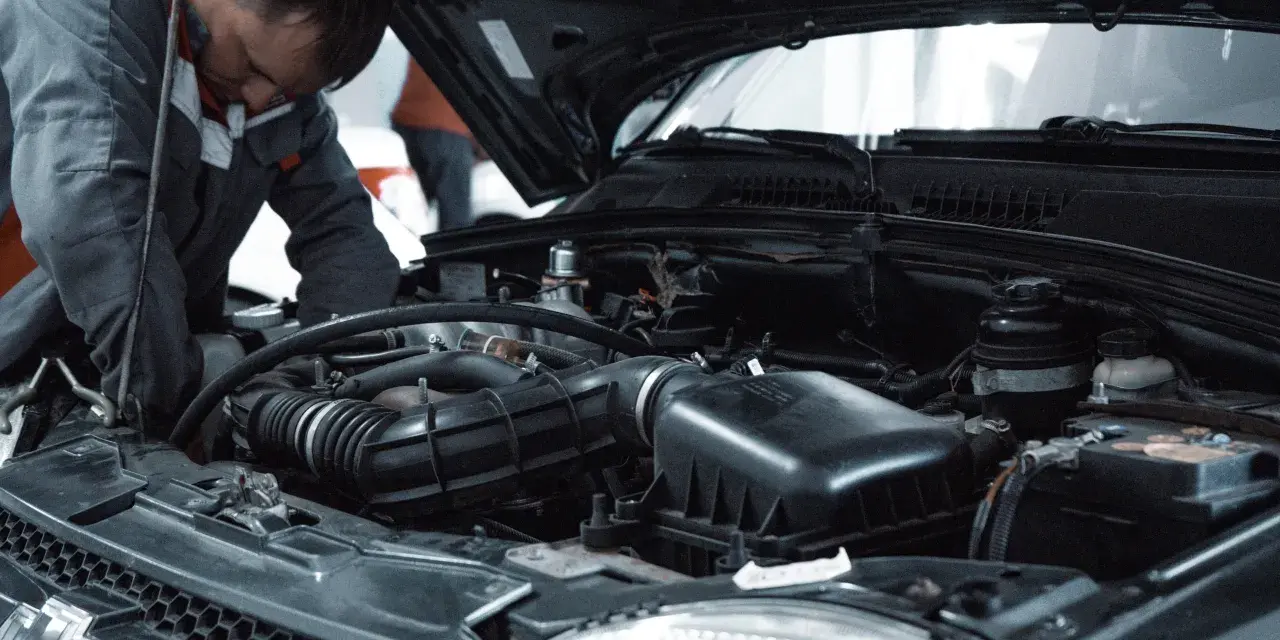 Mechanik pracuje przy silniku, przygotowując się do odpowietrzenia sprzęgła 1.9 TDI.