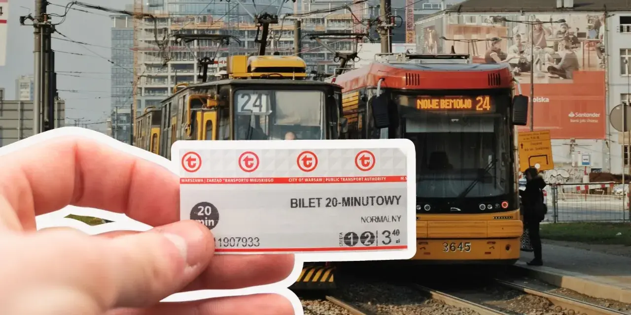 Warszawski bilet 20 minutowy w dłoni, na tle tramwajów i miejskiej zabudowy.