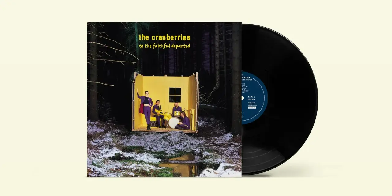 Pochette de l'album "To the Faithful Departed" de The Cranberries, avec un vinyle noir à côté. Le groupe pose dans une structure jaune au milieu d'une forêt enneigée.