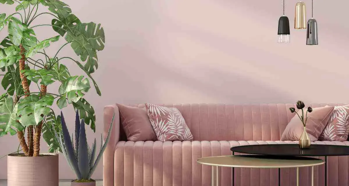 Divano rosa antico e tortora, piante verdi e lampade moderne creano un'atmosfera accogliente.