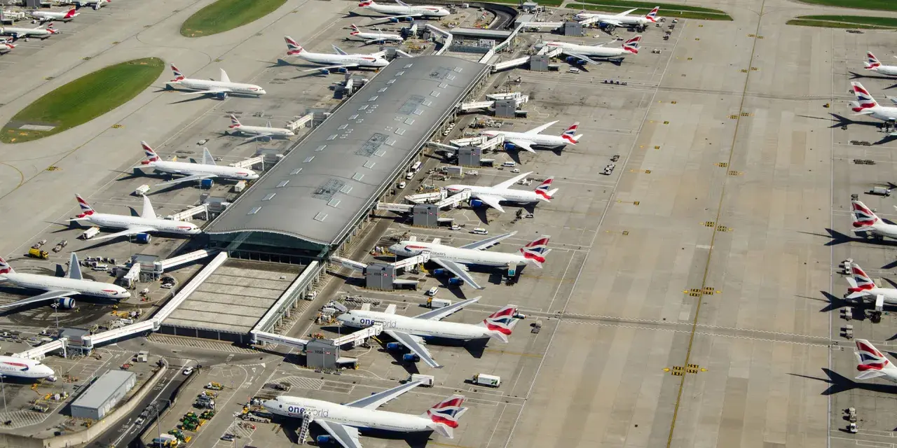 Lotnisko Heathrow tętni życiem, z wieloma samolotami British Airways czekającymi na pasażerów.