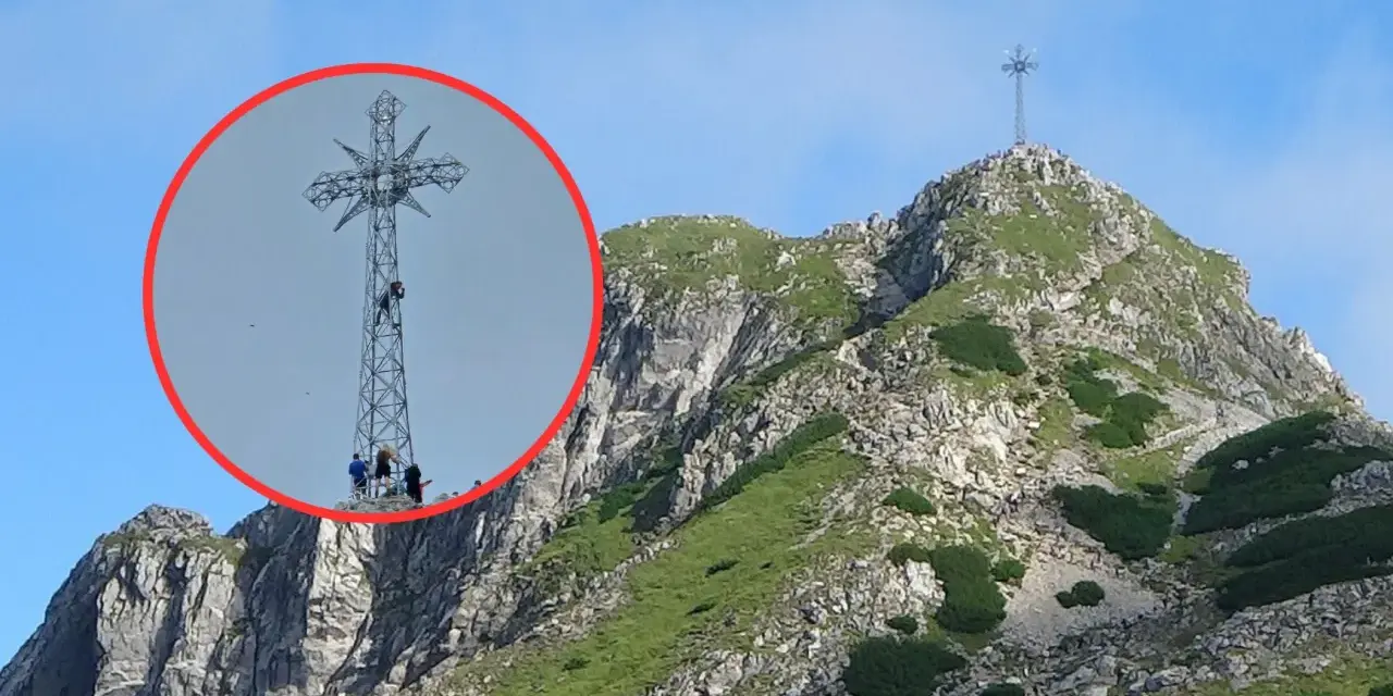 Ludzie wspinają się na krzyż na Giewoncie. Czy krzyż na Giewoncie świeci? Widać go z daleka na tle błękitnego nieba.