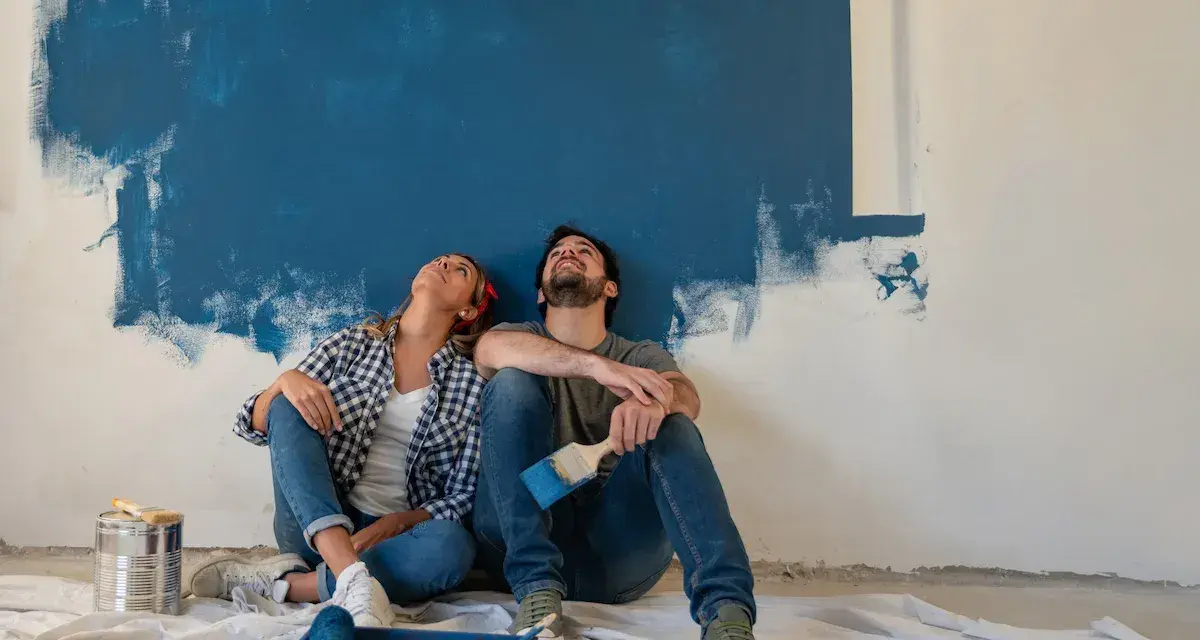 Coppia seduta sul pavimento, guarda in alto verso un muro dipinto di blu. Stacco tra parete e soffitto si o no?