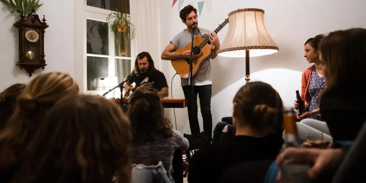 Gemütliches souly konzert berlin. Zwei Musiker spielen Gitarre und Keyboard, während das Publikum zuhört.