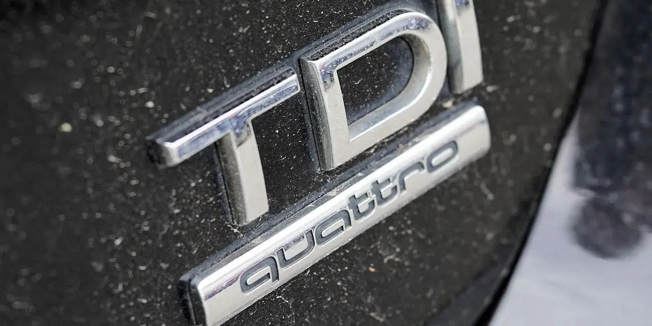 Emblemat TDI Quattro na zakurzonym czarnym lakierze. Zastanawiasz się, audi q5 2.0 tdi ile oleju?