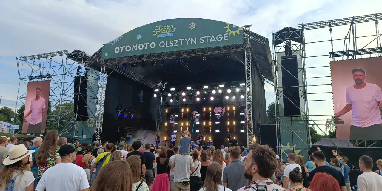 Tłum na festiwalu, na scenie OTOMOTO OLSZTYN STAGE. Kim Nowak w piasku, wśród ludzi.