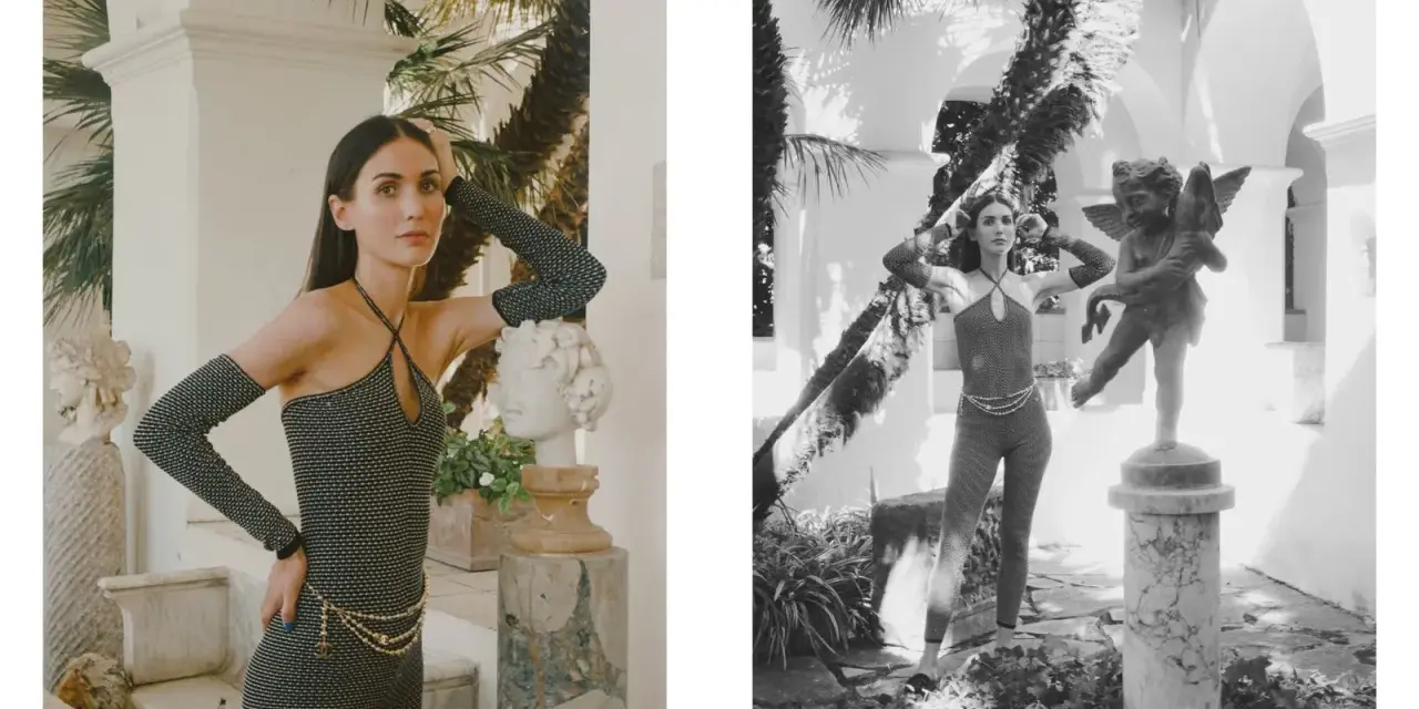 Modella con tuta scintillante e guanti lunghi, ispirata ai coco chanel abiti iconici, posa accanto a statue classiche in un giardino lussureggiante.