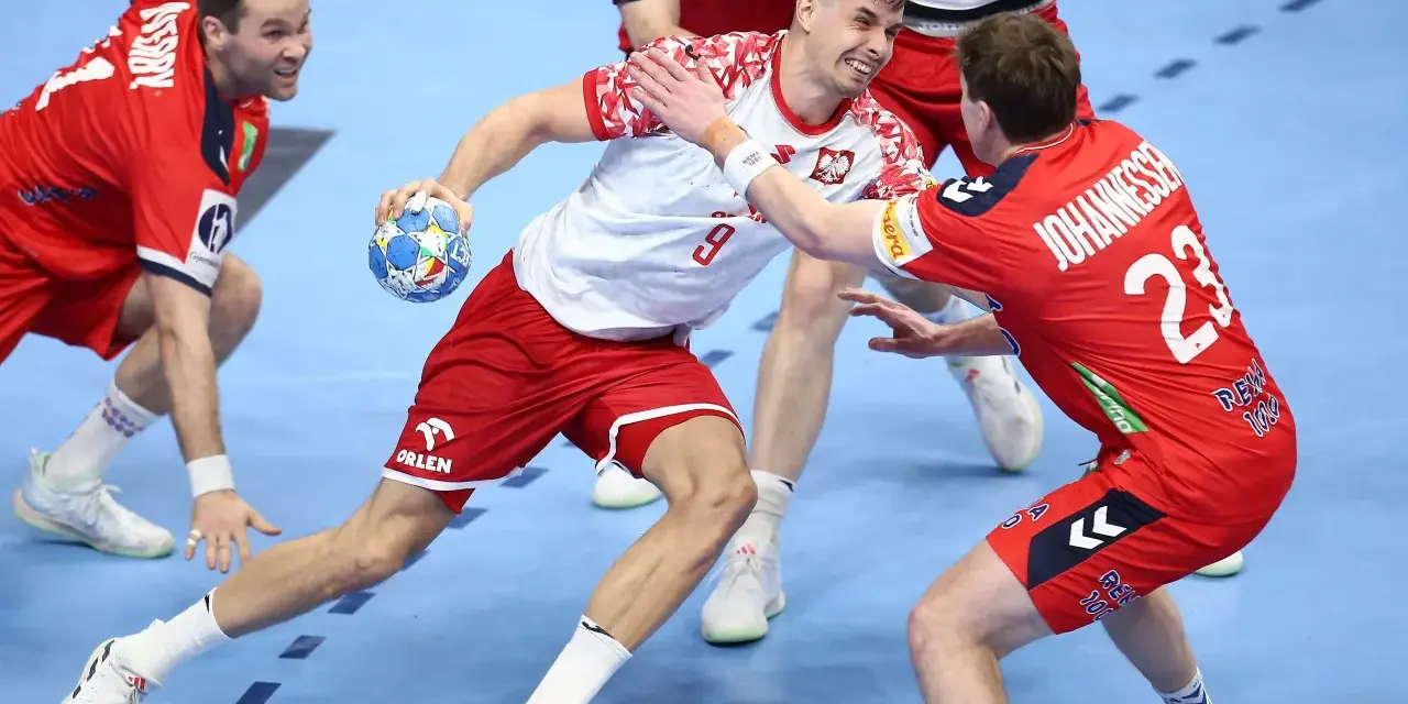 Gracz w białej koszulce z numerem 9 próbuje rzucić piłkę, podczas gdy obrońca w czerwonej koszulce z numerem 23 stara się mu przeszkodzić. Emocjonująca akcja w meczu piłki ręcznej.