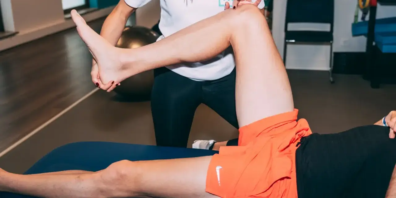 Kinésithérapeute examinant le genou d'un coureur souffrant de douleur.