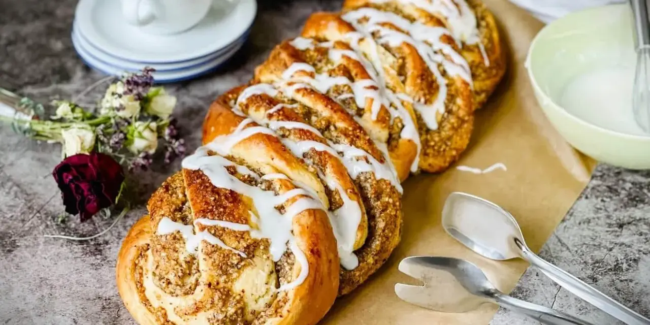 Ein köstlicher Nusszopf, frisch gebacken und mit Zuckerguss verziert. Dieses Nusszopf Rezept ist ein Genuss!