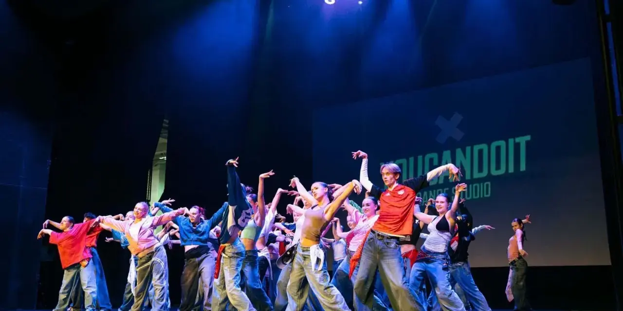 Tancerze na scenie, w ruchu, jakby tworzyli choreografię na żywo. To właśnie improwizacja co to – spontaniczność i kreatywność w tańcu.