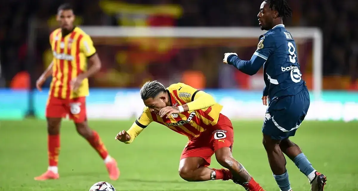 Piłkarz RC Lens w żółto-czerwonym stroju walczy o piłkę z zawodnikiem Stade Rennais.