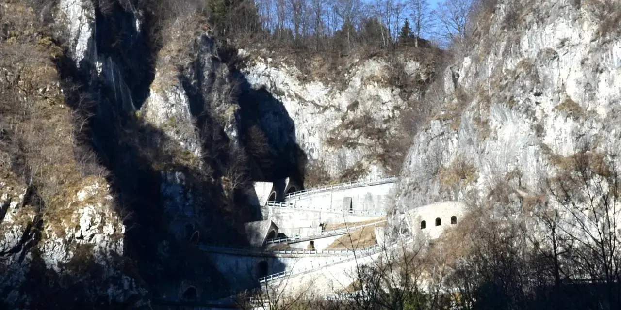 Strada a tornanti sul Passo San Boldo, con gallerie e muri di sostegno che si aggrappano alla roccia.