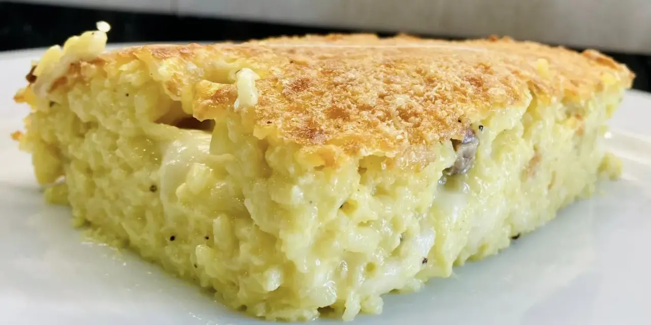 Una fetta di timballo di riso dorato e filante, con un ripieno cremoso e invitante.