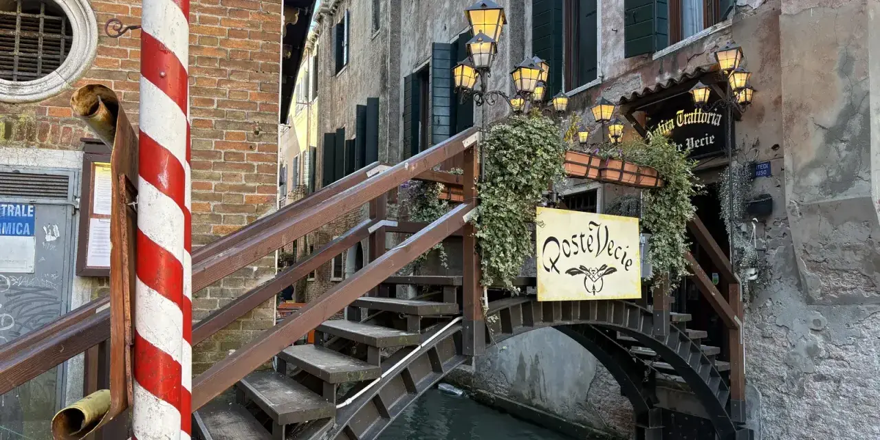 Ponte in legno a Venezia, con insegna "Roste Vecie". Perfetto per un free tour alla scoperta dei vicoli nascosti.