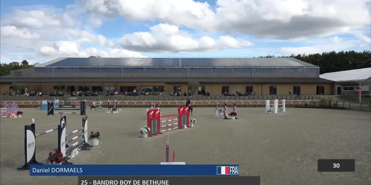 Daniel Dormaels et son cheval 25 - Bandro Boy de Bethune s'élancent sur la piste d'obstacles sous un ciel nuageux.