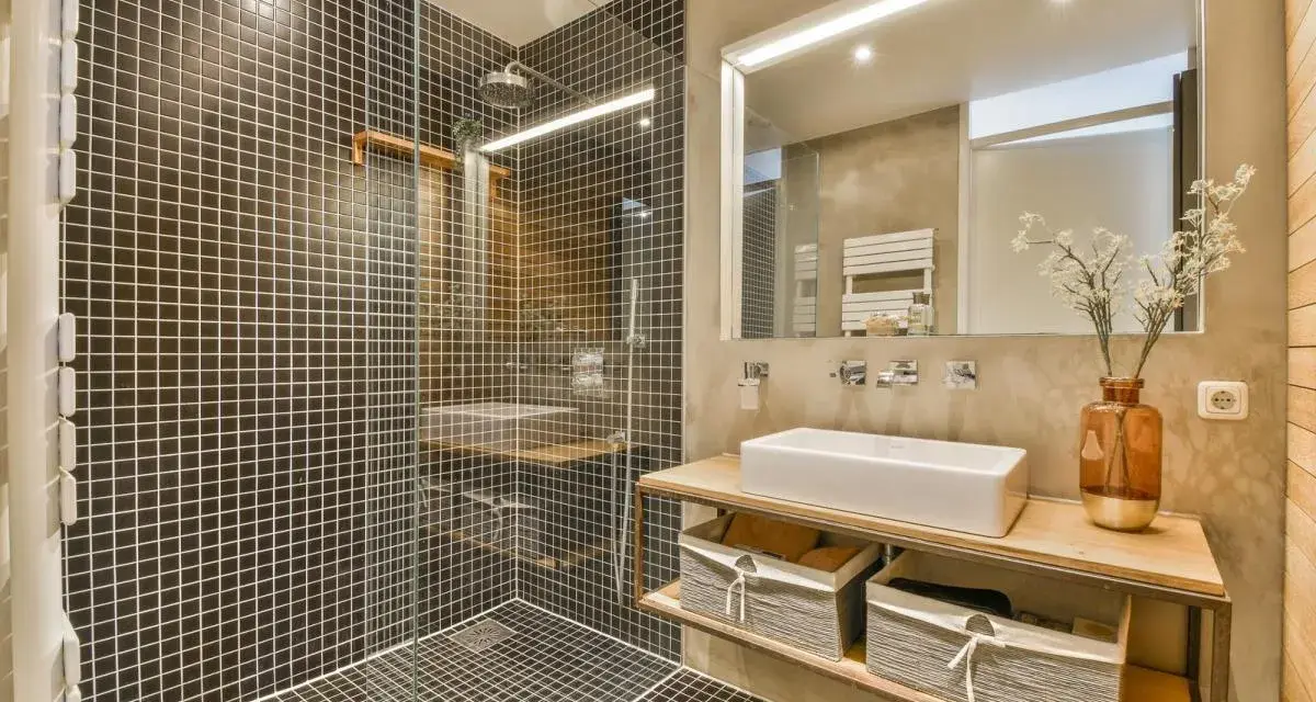 A modern bathroom with a walk-in tiled shower. Learn how to clean a walk-in tiled shower with this stylish setup.