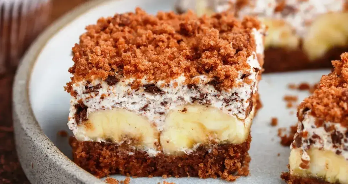 Proste ciasto bananowe z olejem i kakao, z kremem i kawałkami czekolady, posypane kruszonką. Idealne na deser.