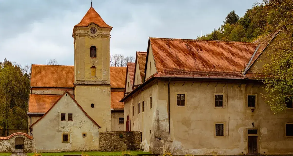 Czerwony Klasztor w Pieninach z wieżą zegarową i pomarańczowymi dachami.