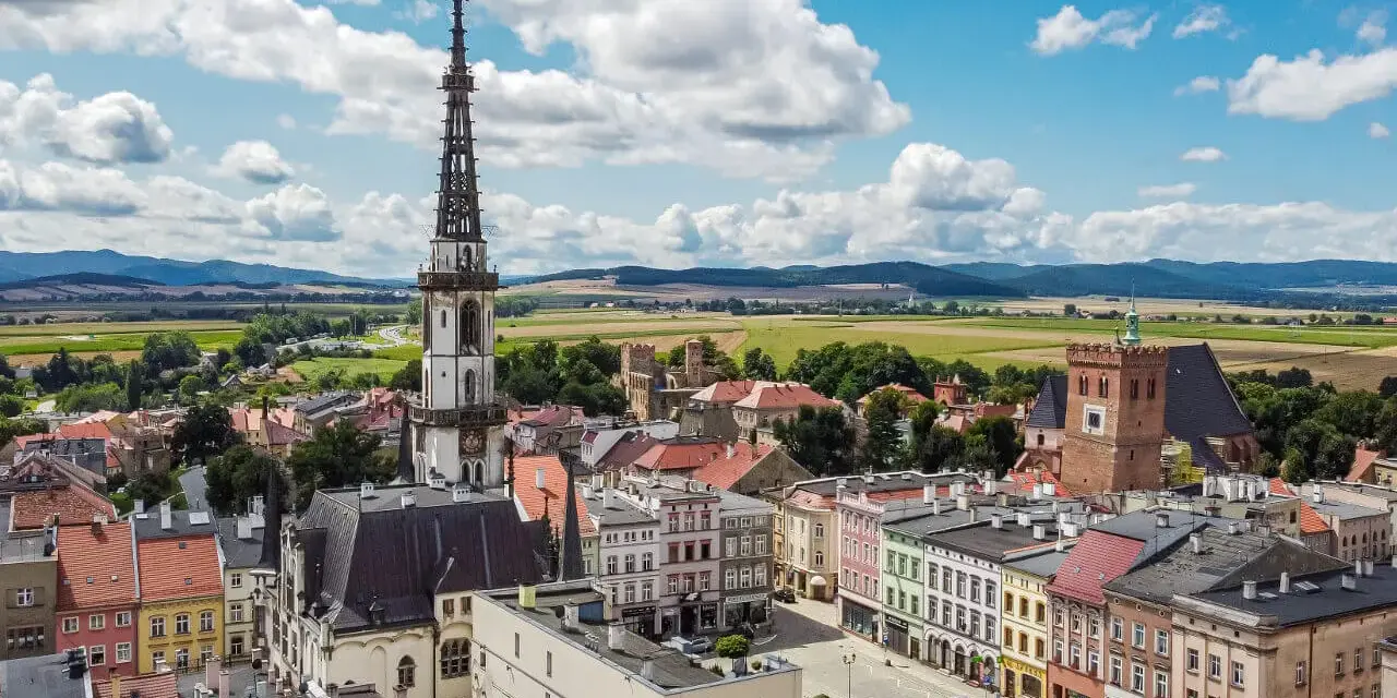 Widok na rynek i wieżę ratuszową w Ząbkowicach Śląskich. Kolorowe kamienice i ruiny zamku to ciekawe ząbkowice śląskie atrakcje.