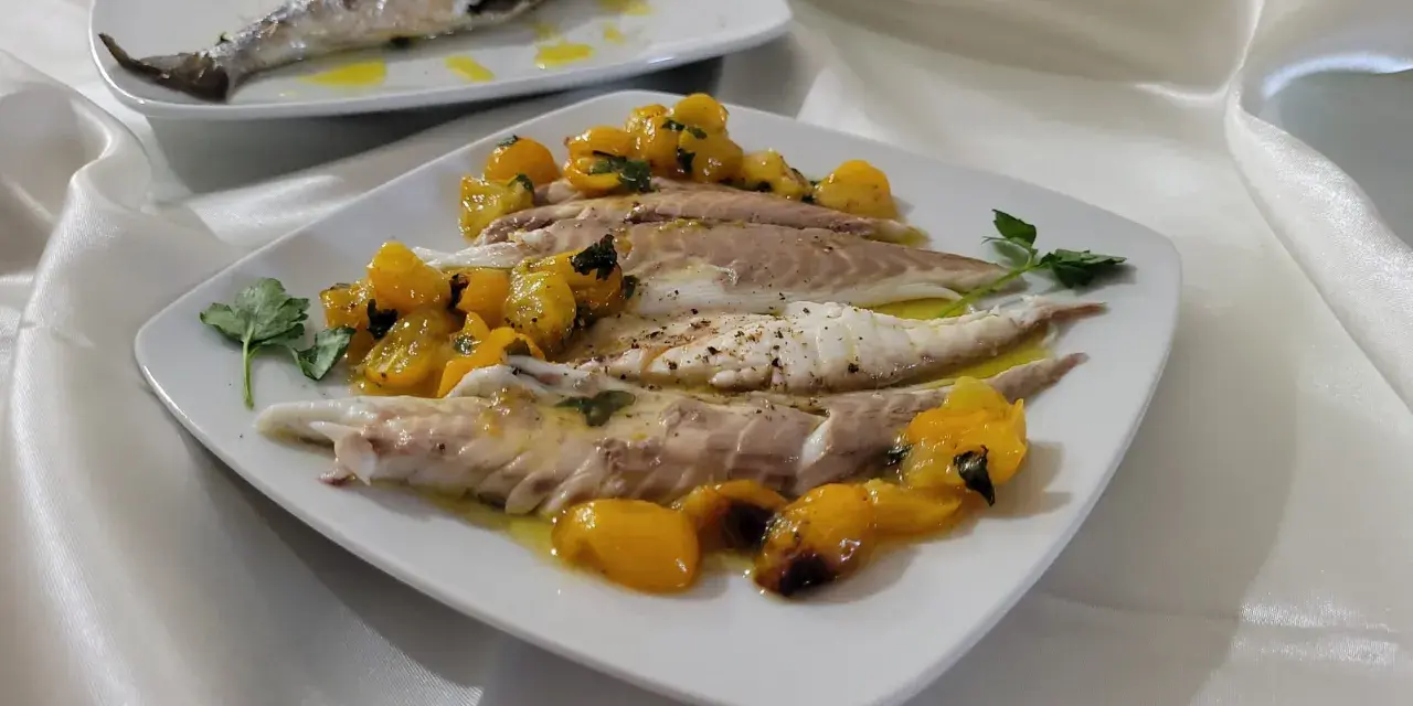 Orata in friggitrice ad aria, servita con pomodorini gialli e prezzemolo. Un piatto leggero e gustoso.