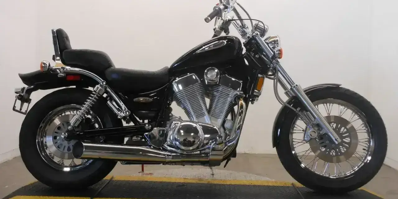 Czarny motocykl Suzuki Intruder 1400 z chromowanymi elementami, siedzeniem pasażera i bagażnikiem.