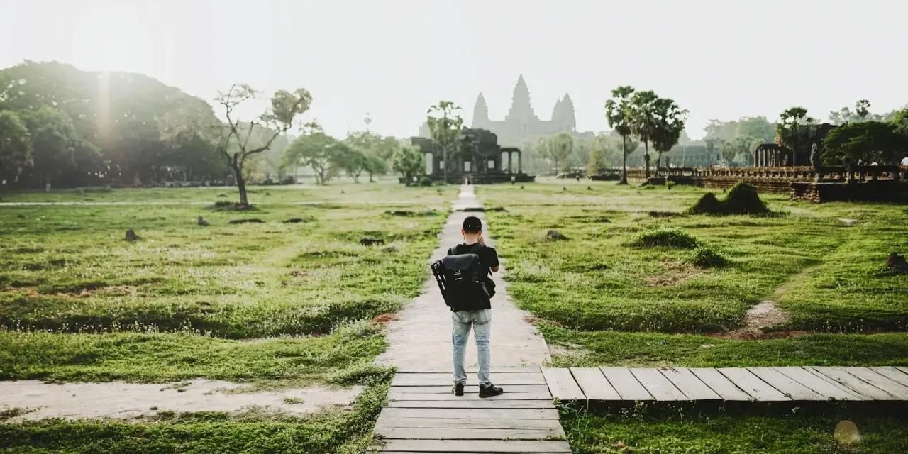 Chłopiec z plecakiem idzie ścieżką do Angkor Wat, jednego z cudów największego kontynentu na ziemi.