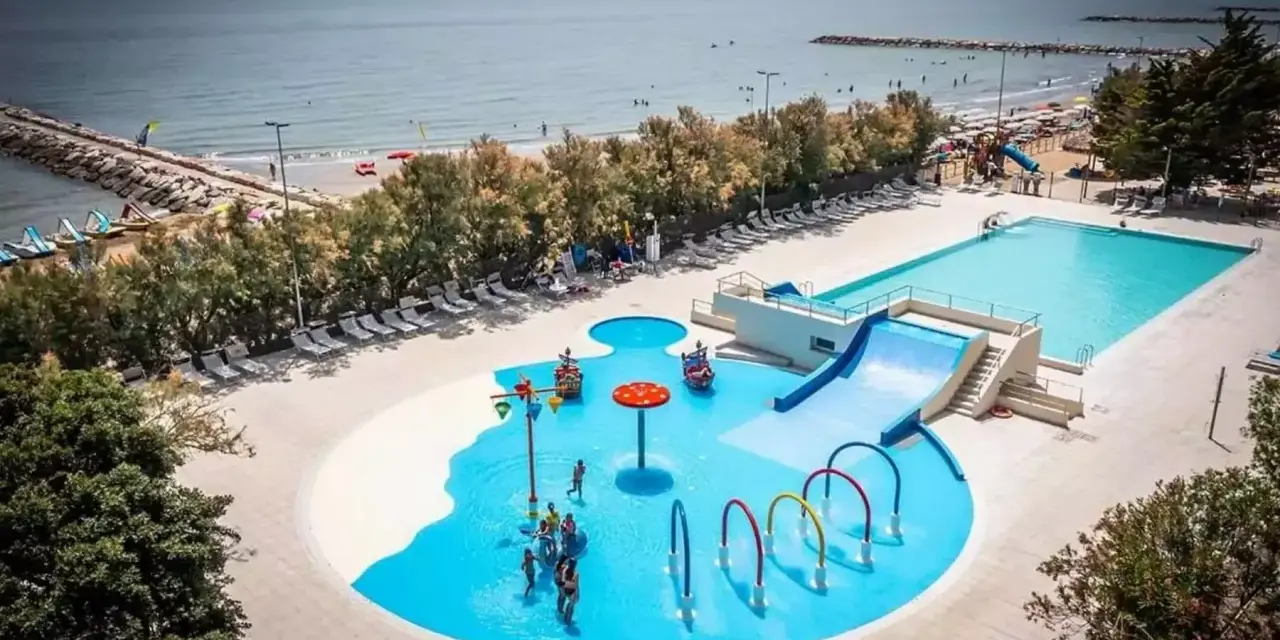 Rodzinna zabawa w wodnym świecie przy plaży w San Francesco Caorle: baseny, zjeżdżalnie i brodziki dla dzieci.