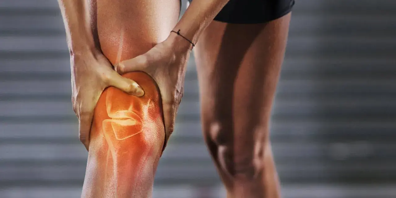 Person hält schmerzendes, dickes Knie. Was tun bei Knieproblemen? Rote Hitze zeigt Entzündung.