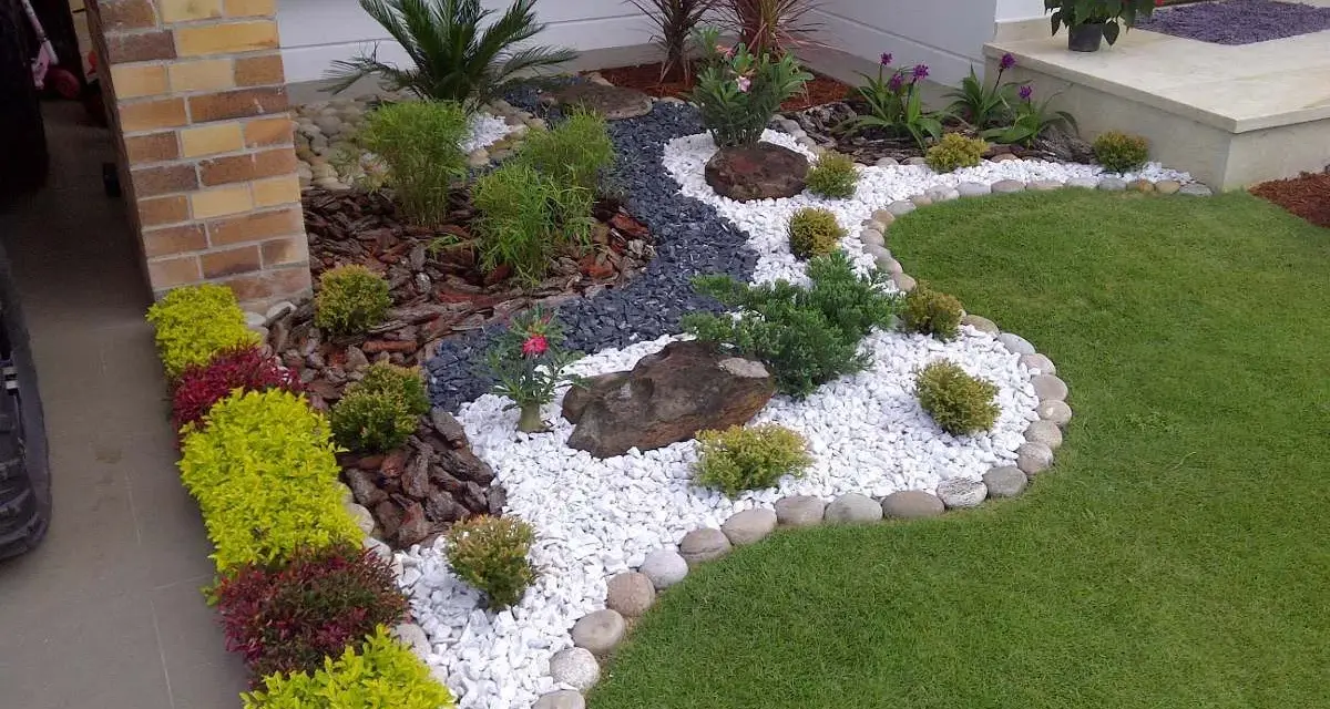 Piccoli giardini da sogno con ghiaia bianca, pietre scure, piante verdi e fiori rossi, un'oasi di pace.