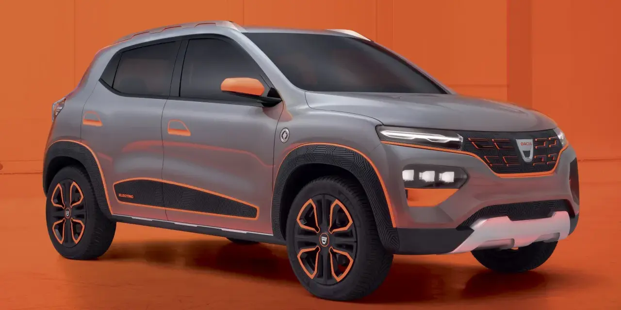 Szary samochód Dacia Spring z pomarańczowymi akcentami na tle pomarańczowym.