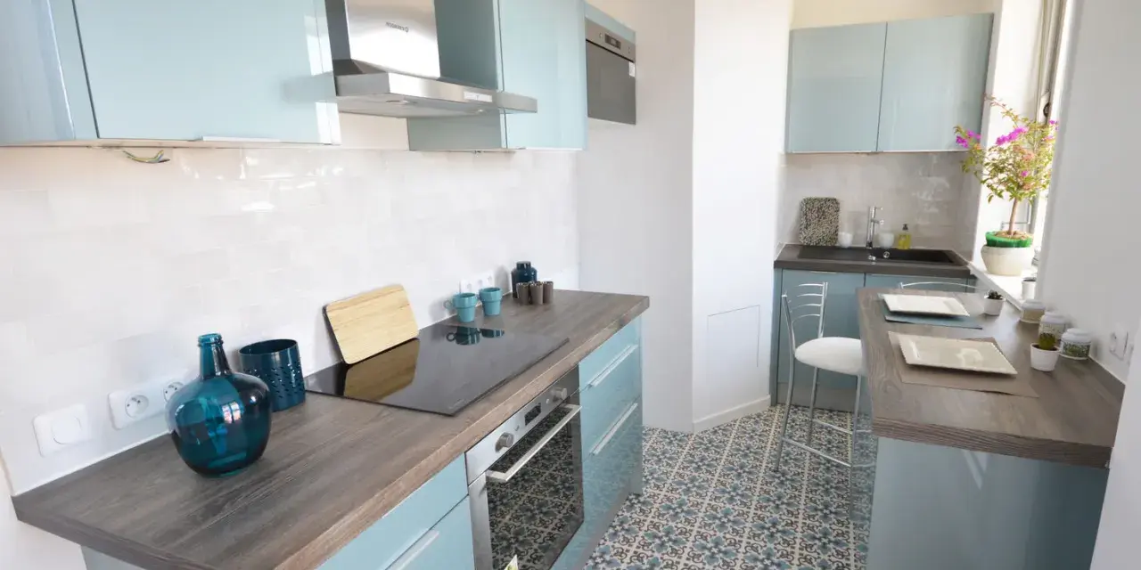 Cocina moderna y luminosa con armarios celestes y suelo hidráulico. Una opción económica para renovar cocina con poco dinero.
