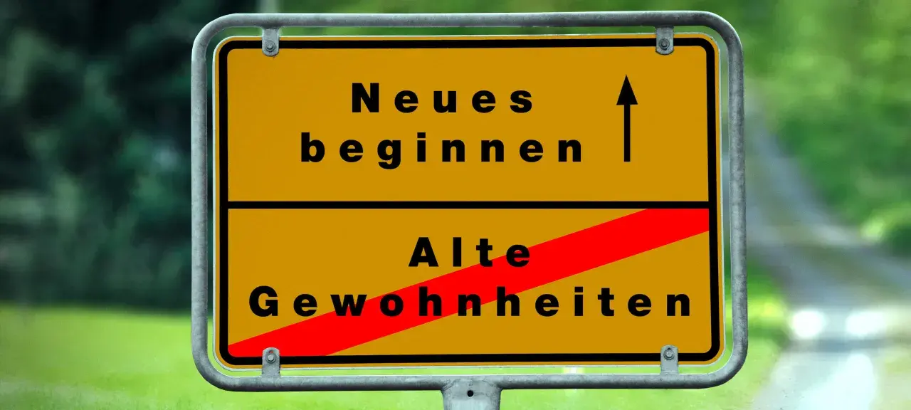 Gelbes Ortsschild: Oben "Neues beginnen" mit Pfeil nach oben, unten "Alte Gewohnheiten" durch roten Balken durchgestrichen. Das Symbol steht für die **passion bedeutung** neuer Wege.