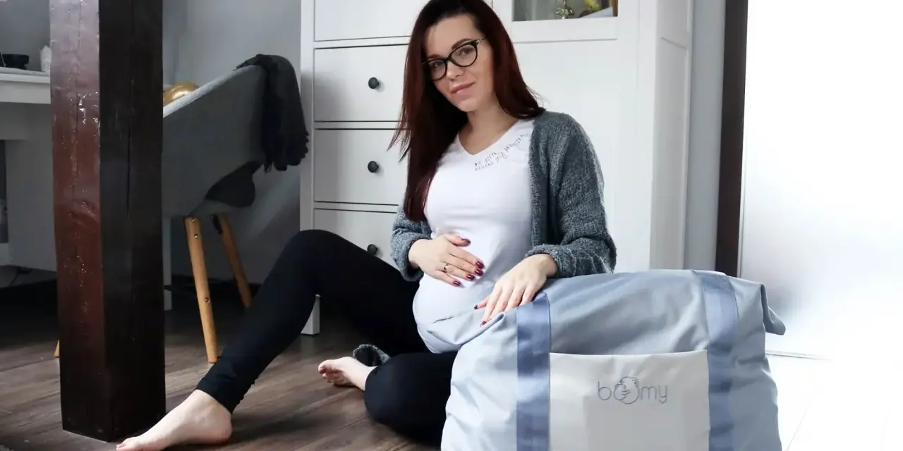 Gotowa na poród! Ciężarna kobieta z torbą, czyli wyprawka do szpitala czeka.