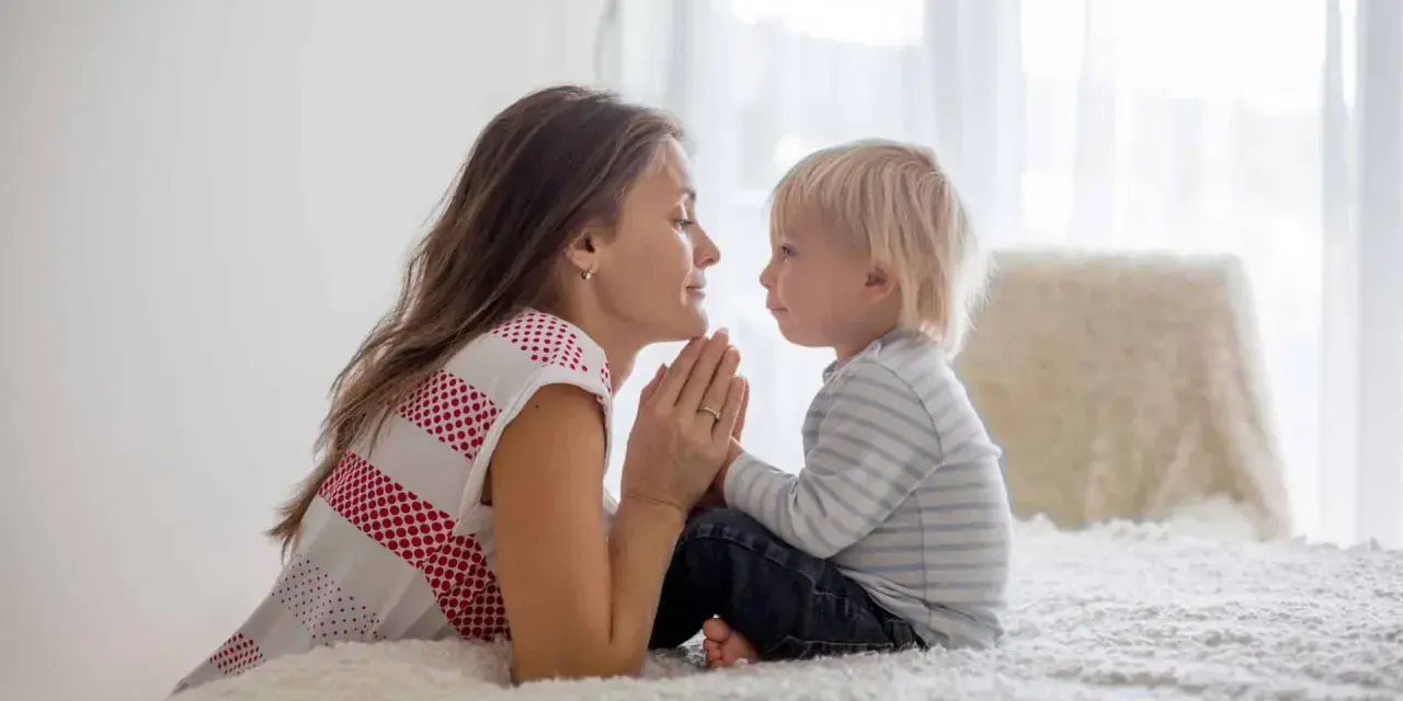 Mutter und Sohn beten gemeinsam. Ein schönes Beispiel für christliche Erziehung, das Vertrauen und Liebe lehrt.