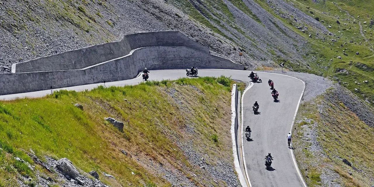 Motocykliści przemierzają kręte trasy w górach, ciesząc się wolnością i pięknymi widokami. To idealne miejsce na odkrywanie polskich tras motocyklowych.