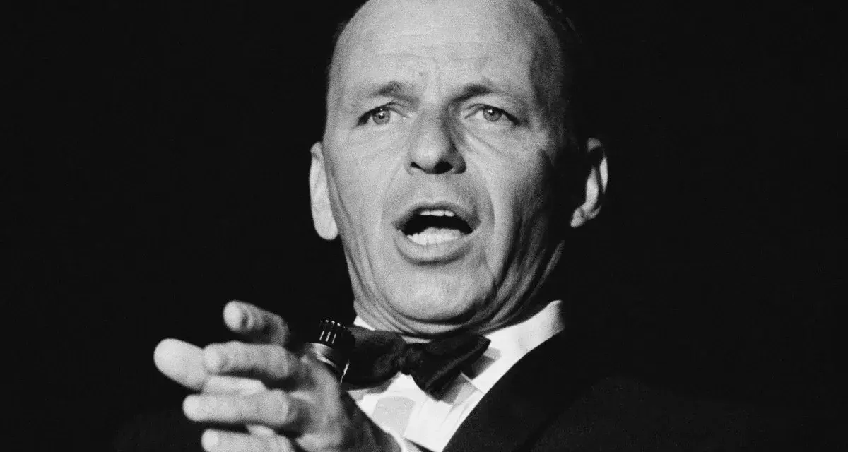 Frank Sinatra, Meister des Swing und der Popmusik, singt mit Leidenschaft ins Mikrofon. Seine Musikrichtung ist unverkennbar.