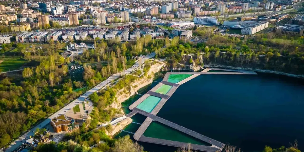 Widok na krakowski Zakrzówek z basenami i drewnianymi pomostami. Sprawdź zakrzówek cennik i zaplanuj relaks.